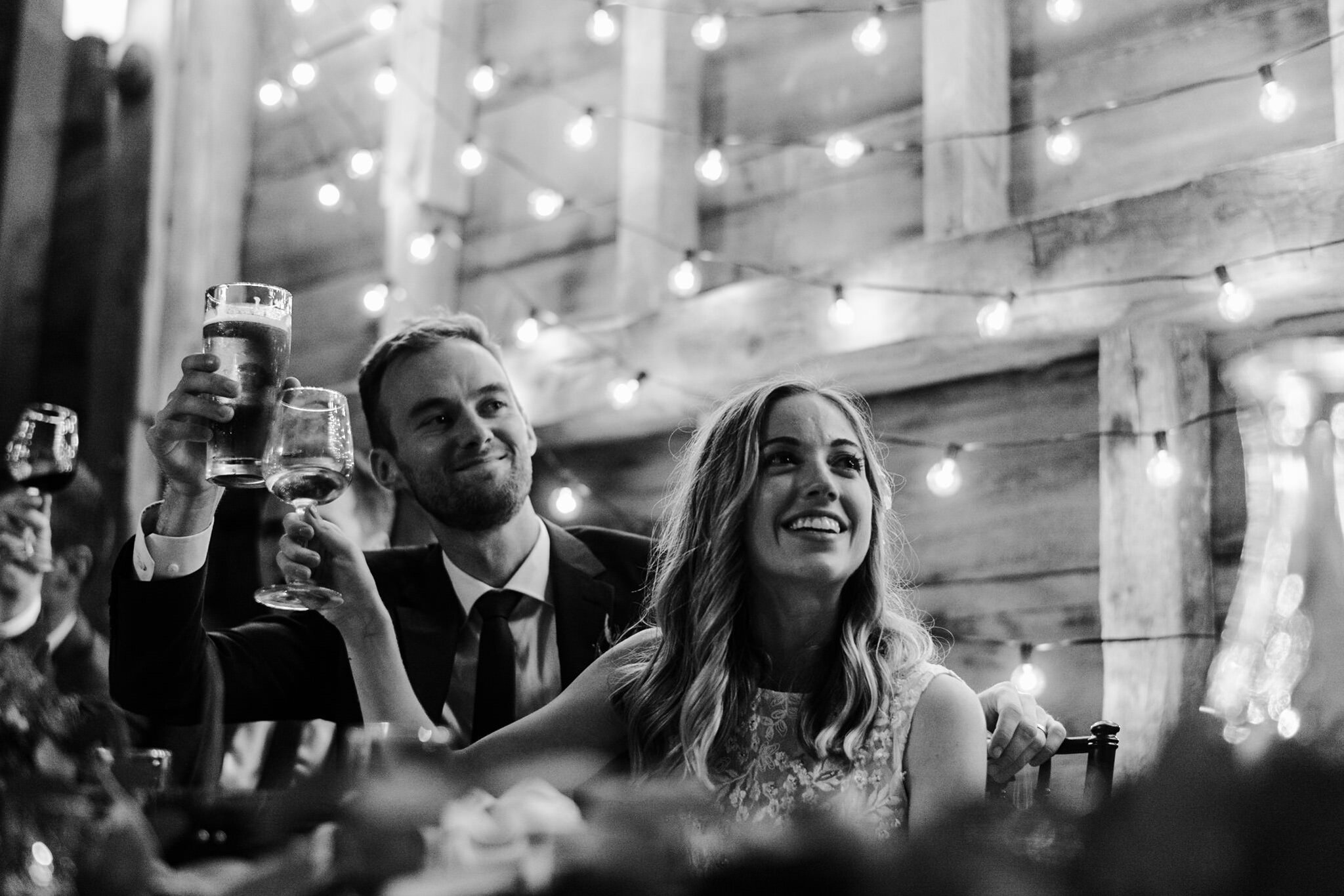 075-bride-groom-speech-barn-reception-string-lights-romantic.jpg