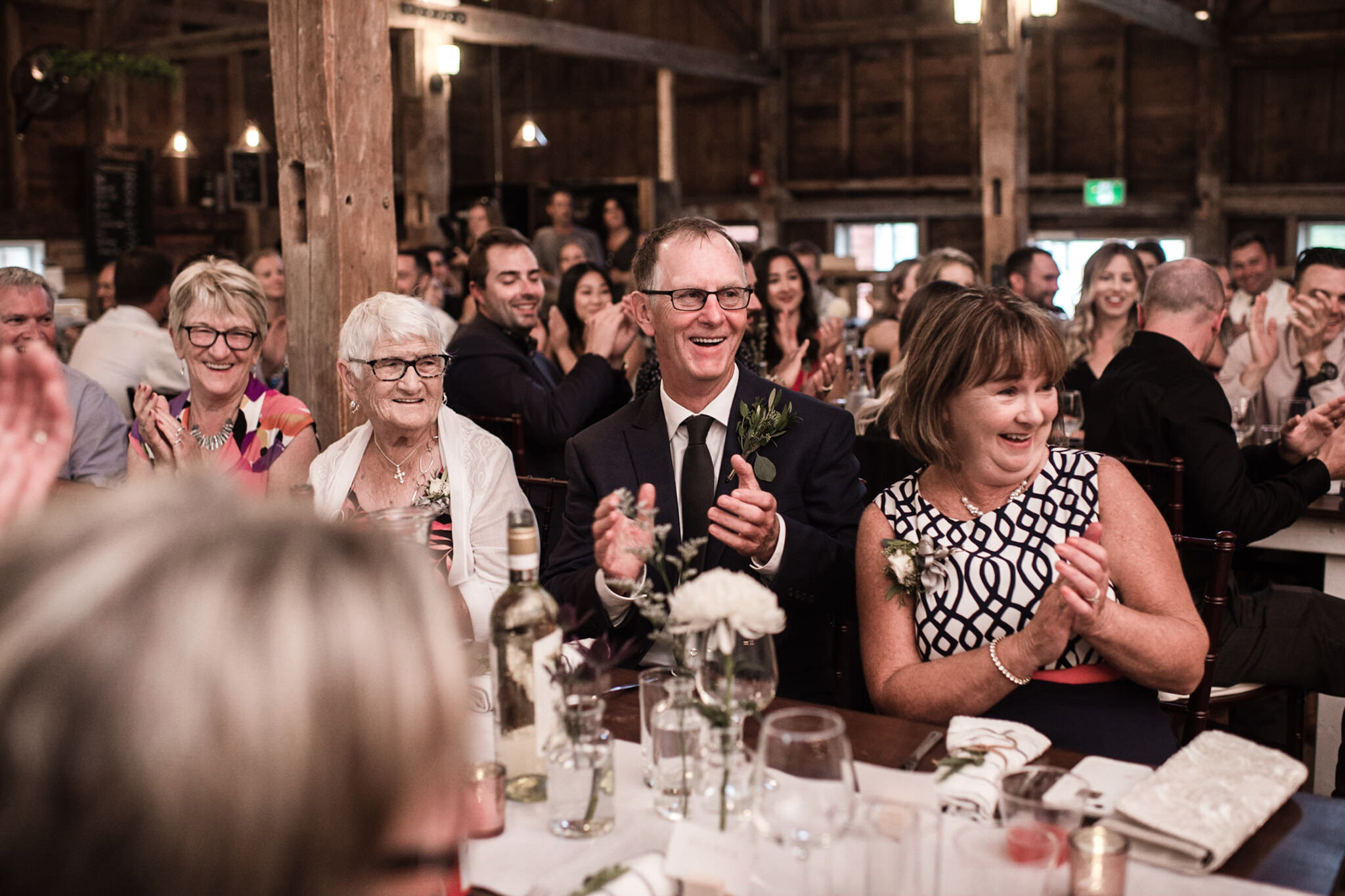 096-parents-of-groom-speech-reactions-reception-in-barn-romantic.jpg